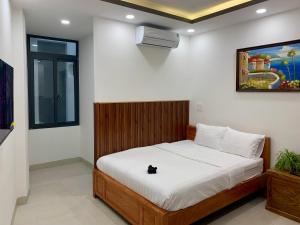 ein Schlafzimmer mit einem Bett, auf dem eine schwarze Katze sitzt in der Unterkunft The Nam’s House-Nha Trang in Nha Trang