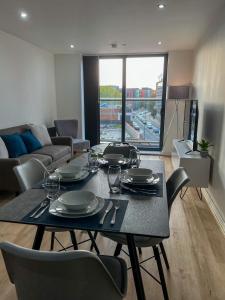a dining table and chairs in a living room at Elmardi Residence - 2 Bedroom Apartment City Centre in Birmingham