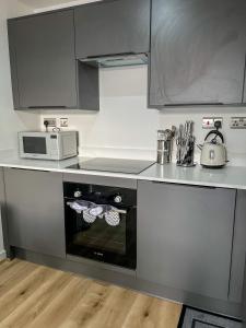 a kitchen with a stove and a microwave at Elmardi Residence - 2 Bedroom Apartment City Centre in Birmingham +5 photos