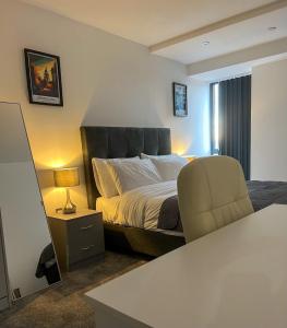 a hotel room with a bed and a chair at Elmardi Residence - 2 Bedroom Apartment City Centre in Birmingham