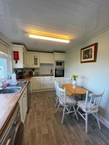 a kitchen with a wooden table and chairs and a table at Sandpit Cottage in Browns Cross Roads +6 photos