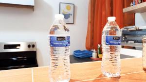 dos botellas de agua sentadas sobre una mesa en SAN BENITO FLATS WIFI 50MG - 4 HUESPEDES - PARQUEOS en San Salvador