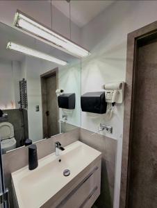 La salle de bains est pourvue d'un lavabo et d'un miroir. dans l'établissement Eddie's Luxury Apartments, à Gliwice