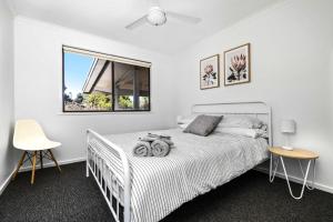 1 dormitorio con cama blanca y ventana en Seabreeze Cottage Cape Paterson, en Cape Paterson