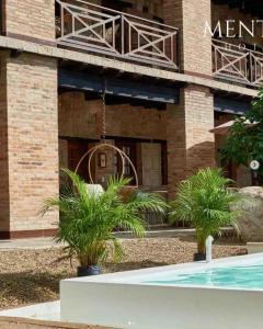 a hotel with a swimming pool in front of a building at Mentto Hotel in Guaduas