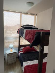 a bedroom with two bunk beds and a window at Apartamento en Metro Ñuble in Santiago