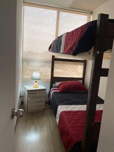 a bedroom with a bunk bed next to a window at Apartamento en Metro Ñuble in Santiago