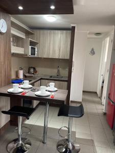 a kitchen with a table and chairs in a room at Apartamento en Metro Ñuble in Santiago