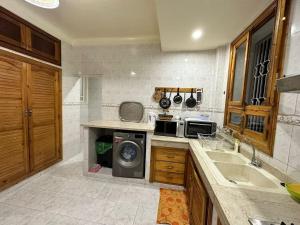 uma cozinha com um lavatório e uma máquina de lavar roupa em Jawhara Jacobs apartment em Fez
