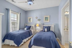 two beds in a bedroom with blue walls at 2BR 2BA Waterfront Villa 10min to Beach and Market Common in Myrtle Beach