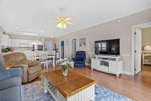 a living room with a couch and a tv and a table at 2BR 2BA Waterfront Villa 10min to Beach and Market Common in Myrtle Beach