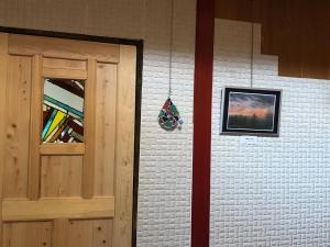 a brick wall with a door and a picture at 陽なた山荘 in Azumino