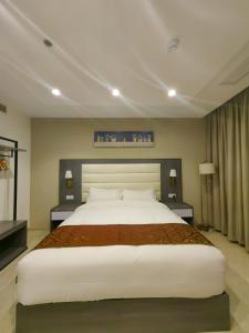 a large bedroom with a large white bed in it at Wave View Hotel in Seeb