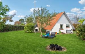 um quintal com duas cadeiras e uma lareira em frente a uma casa em Cozy Home In Bogense With Wifi em Bogense
