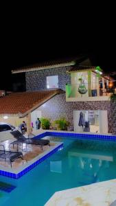 una piscina por la noche con una villa en Casa mar sol e piscina, en Peruíbe