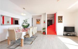 a dining room with a table and chairs and a red door at Beautiful Home In Omis With House Sea View in Zakučac