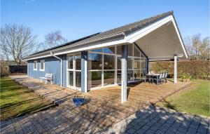 a house with a large deck with a patio at Stunning Home In Esbjerg V With Kitchen in Esbjerg
