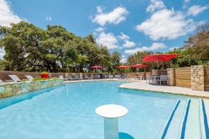 une grande piscine avec des chaises et des parasols dans l'établissement Comfy BoHo 2BD Apt in Cedar Park/North Austin, à Austin