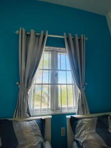 a bedroom with a window with curtains next to a bed at Homestay BONO Mũi Né in Phan Thiet