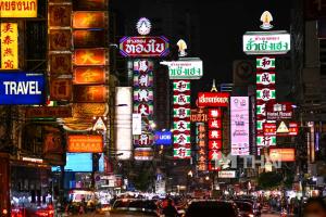 a busy city street at night with neon signs at GO INN The Grand Palace - โกอินน์ พระบรมมหาราชวัง-วัดพระแก้ว in Bangkok