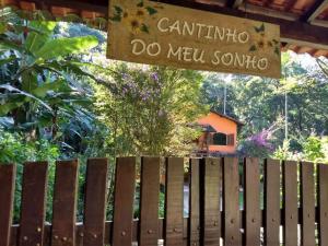 裴尼多的住宿－Casa em penedo com cachoeira，木栅栏,上面有读卡通提纳的标志