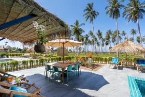 patio ze stołem i krzesłami oraz basenem w obiekcie Manao Seaview Pool Villa 25 - 5 Mins Walk To The Beach w mieście Ko Lanta
