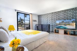 sypialnia z dużym łóżkiem i telewizorem z płaskim ekranem w obiekcie Manao Seaview Pool Villa 25 - 5 Mins Walk To The Beach w mieście Ko Lanta