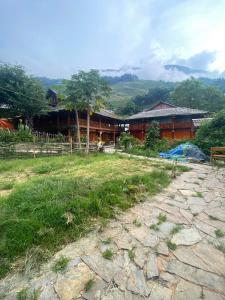 a house with a grass field in front of a building at Mekhoo & Zizi Sapa Homestay in Sa Pa