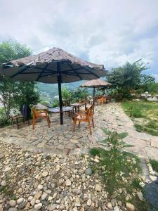 un patio con tavoli, sedie e ombrellone di Mekhoo & Zizi Sapa Homestay a Sa Pa