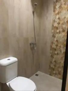 a bathroom with a toilet and a shower at Phoenix Guest House in Surabaya