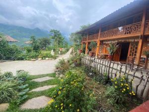 a building with a fence next to a garden at Hmong Sister House and Trekking in Sa Pa