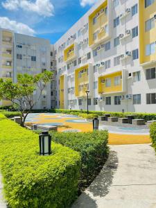 a building with yellow and white buildings and bushes at 4138 Davao City 2bedroom unit 8 Spatial Maa by Filinvest in Davao City