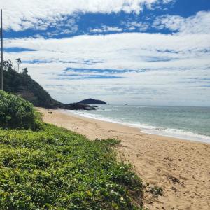 a sandy beach with a view of the ocean at Pousada Canto Gira Sol Penha SC Estúdio Sol 5 Min do Beto Carrero in Penha +1 photo