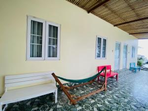 een veranda met 2 banken en een hangmat bij Homestay BONO Mũi Né in Phan Thiet