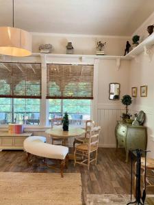 a living room with a table and chairs and windows at The Shopkeeper's Cottage ~ CHIC! in Amador City