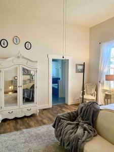 a bedroom with a bed and a mirror and a chair at The Shopkeeper's Cottage ~ CHIC! in Amador City