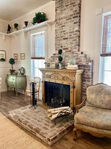 a living room with a fireplace and a chair at The Shopkeeper's Cottage ~ CHIC! in Amador City