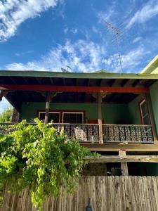 una casa verde con una valla de madera delante de ella en The Shopkeeper's Cottage ~ CHIC! en Amador City