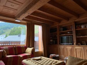 a living room with a couch and a large window at Chesa Cotschna in Celerina