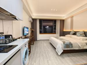 una camera d'albergo con letto e cucina di Zhangjiajie Porui Hotel - Tianmen Mountain a Zhangjiajie