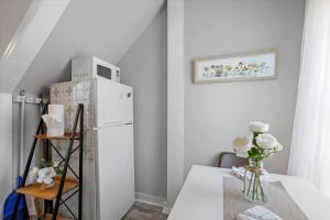 a kitchen with a table with a white refrigerator at Modern 2 Bdrm 10 Mins Metro To City Center in Philadelphia