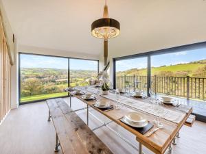 a dining room with a table and large windows at Westpitt Farm - The Hay Loft in Tiverton