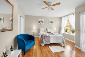 a bedroom with a bed and a blue chair at Modern And Cozy 2br Apt in Philadelphia