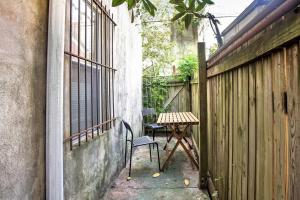 a table and a chair in a courtyard next to a fence at A Spacious Lovely 2 Bedroom Flat With Private Yard in Philadelphia