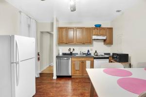 a kitchen with a white refrigerator and wooden cabinets at A Spacious Lovely 2 Bedroom Flat With Private Yard in Philadelphia