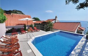 Zakučac的住宿－奧米甚普特博爾卡度假屋，房屋旁的游泳池配有椅子和遮阳伞