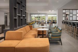 vestíbulo con sofá, mesas y sillas en TownePlace Suites by Marriott Cincinnati Mason en Mason