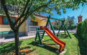 plac zabaw z pomarańczową zjeżdżalnią na drzewie w obiekcie Beautiful Home In Fazana With Kitchen w Fažanie