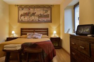 Un dormitorio con una cama y un televisor. en Ruta del Tiempo, en Sos del Rey Católico