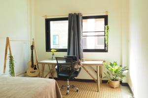 a bedroom with a desk and a chair and a guitar at Poke Pai Home in Pai